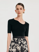 a lady in a black seamless asymmetric neck woolen knit top